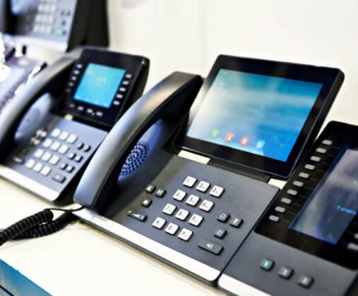 VoIP phones lined up on a table, set up by TotalBC solutions in the Carolinas
